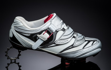 one road cycling shoe standind at small metal sprocket
