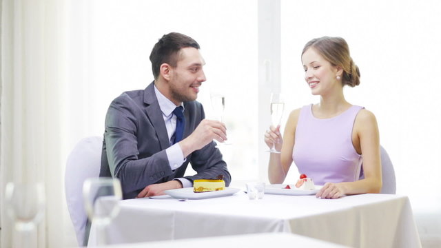 smiling couple with champagne at restaurant
