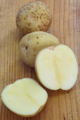 Naklejka na ściany i meble Small new potatoes on a wooden