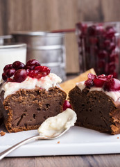 chocolate cake with cream cheese, raw cherry on white plate