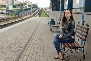 Attractive woman sitting on a bench waiting
