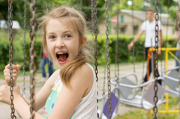 Excited little girl on a ride at the fairground