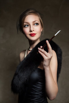 Woman in luxury fur. Retro style. Dark background