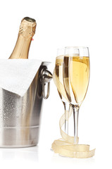Champagne bottle in ice bucket, two glasses and christmas decor