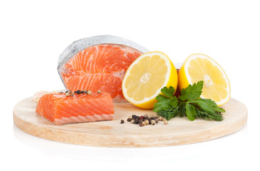 Salmon on cutting board with lemons and herbs