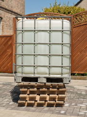 Ein Wassertank in einer Gitterbox auf Holzpaletten