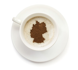 Cup of coffee with foam and powder in the shape of Germany.(seri