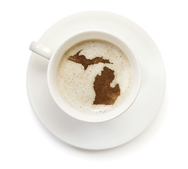 Obraz premium Cup of coffee with foam and powder in the shape of Michigan.(ser
