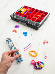 loom banding tools and multicoloured elastic bands with a mans h