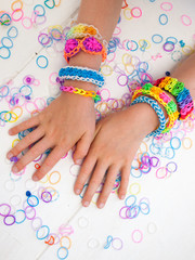 childs arms wearing multicoloured bracelets