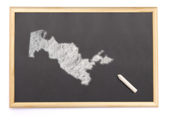 Blackboard with a chalk and the shape of Uzbekistan drawn onto.