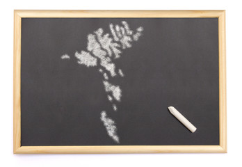 Blackboard with a chalk and the shape of Faroe Islands drawn ont