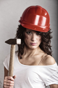 Sexy girl in safety helmet holding hammer tool