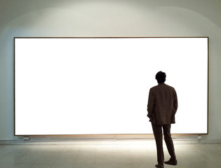 Man in gallery room looking at empty frames