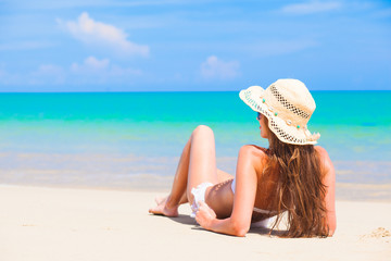 Fototapeta na wymiar woman in straw hat lying on tropical beach