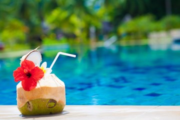 exotic fresh coconut shake and flower by the tropical pool © el.rudakova