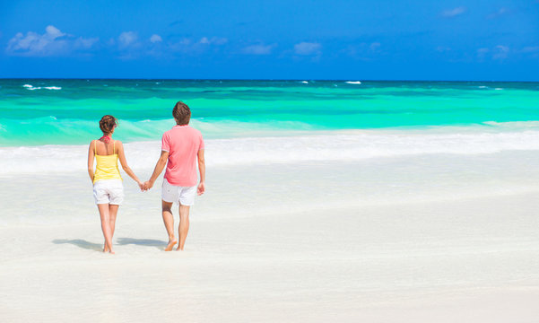happy young couple walking at tropical beach