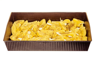 Raw peeled potatoes with spices and butter in tray