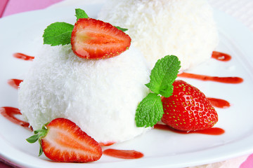 Delicious coconut cakes on plate on table close-up