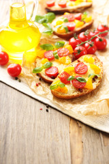 Tasty bruschetta with tomatoes, on old wooden table
