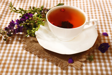 Cup of fresh herbal tea on table
