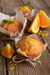 Tasty cupcakes with orange on table close-up
