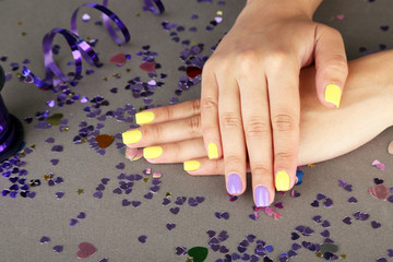 Obraz na płótnie Canvas Female hand with stylish colorful nails, on bright background