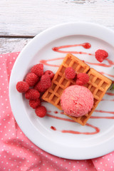 Tasty belgian waffles with ice cream on wooden table