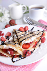Delicious pancakes with berries on table close-up