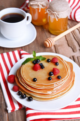 Sweet pancakes with berries on table close-up