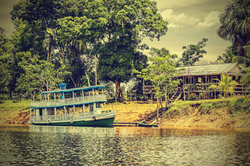 Retro toned picture of a wooden boat on the Amazon river, Brazil.
