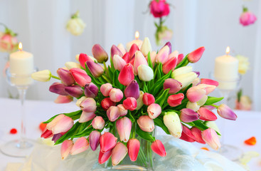 festive table decorated with a bouquet of tulips, candles