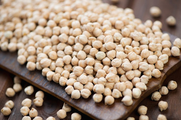 Raw chickpeas on a rustic wooden chopping board, studio shot