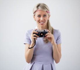 Vintage fashioned young woman holding old film camera