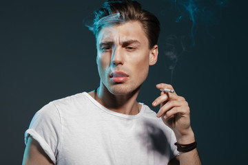 Handsome young man smoking cigarette