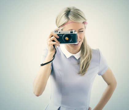 Young woman taking selfie with old film camera