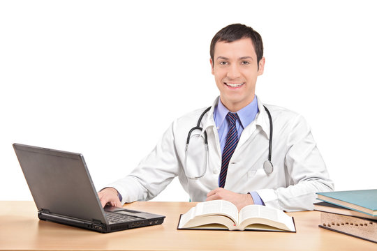 Doctor sitting at a desk and working on laptop