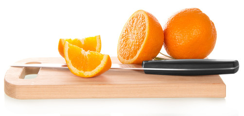 Orange sliced with knife on cutting board