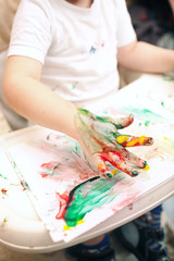 Obraz na płótnie Canvas Boy painting with finger-paints