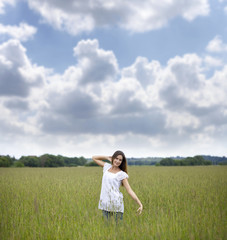 Young woman walks in summer field