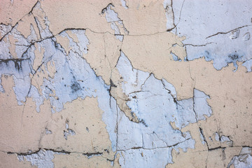 Fototapeta premium Cracked concrete surface with the remains of sandy-tan paint
