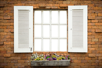 Fototapeta na wymiar Open Window With Flower Basket On Brick Wall