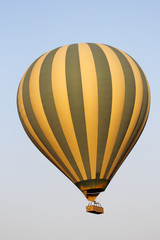Naklejka premium Latający zielony i żółty balon na ogrzane powietrze
