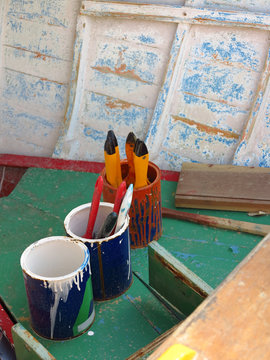 Paint pots and brushes in an old fishing boat