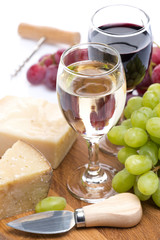 grapes, hard cheese and two glasses of wine, vertical