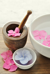 Fototapeta na wymiar Flowers in a water bowl with a candle and a wooden pestle for ar