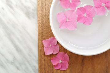 Flowers in a water bowl for aromatherapy on a wooden background
