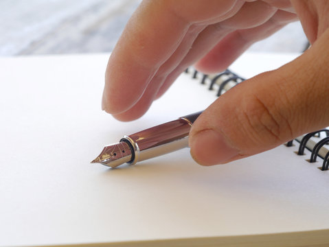 Close up of human hand with pen