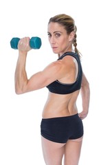 Fototapeta na wymiar Female bodybuilder holding a blue dumbbell looking at camera
