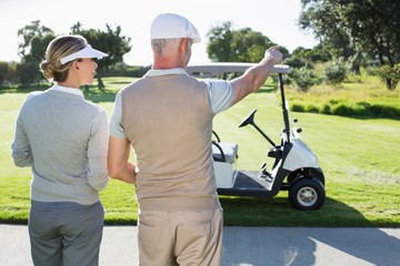 Happy golfing couple looking out to the course